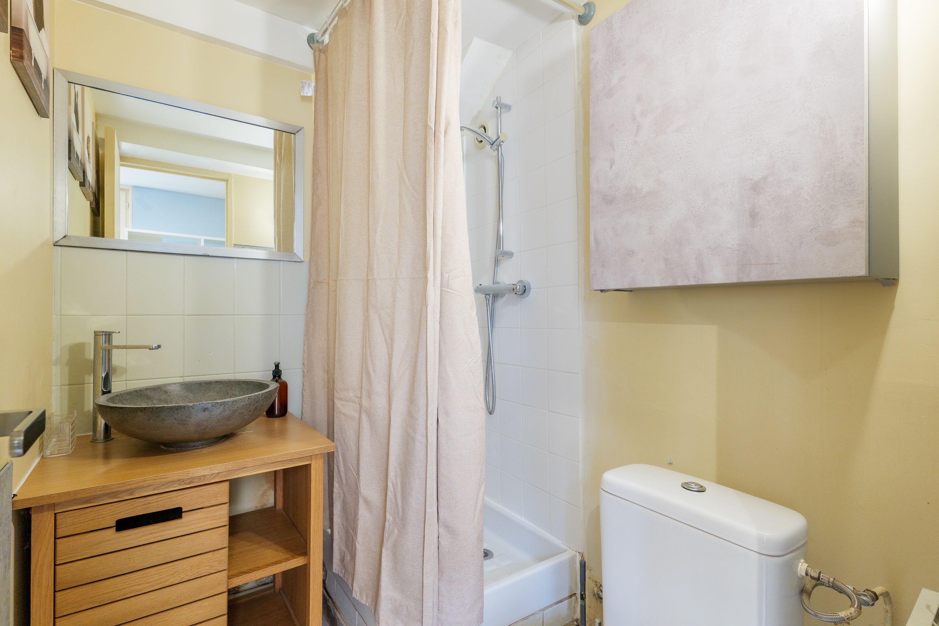 Une salle de bain avec un grand lavabo, une douche et des toilettes.