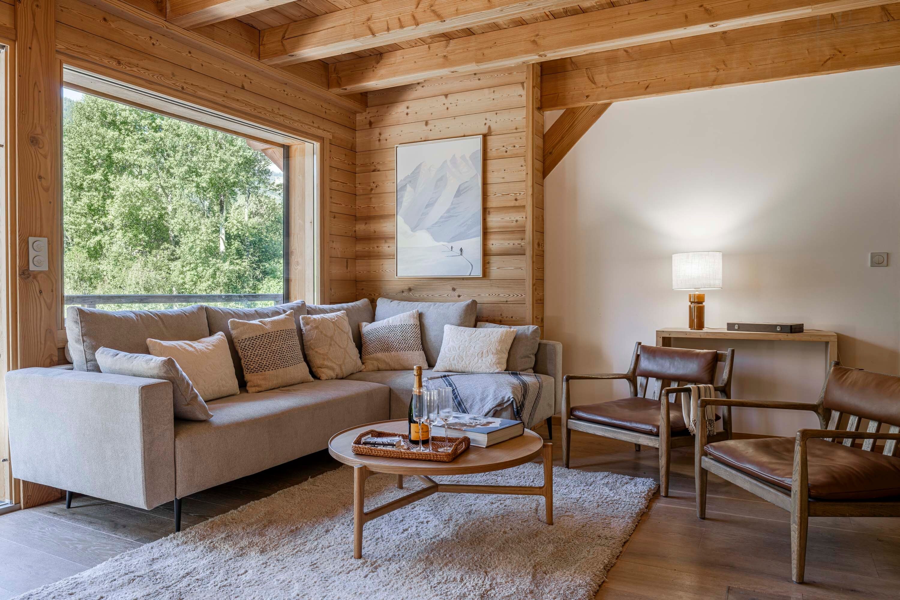 A cozy living room with a sofa, armchairs, a coffee table, and a painting on the wall.