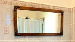 A bathroom with a sink, mirror, and toiletries. - Casita de Playa Bomalu (Las Peñitas)
