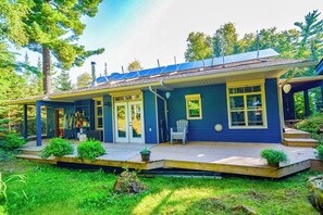 A two-story house with a covered porch, a front door, and a small deck area. - 5 minute boat ride from harbour front .superb fishing or swim off the dock . (Kenora)