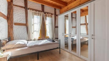 A bedroom with a bed, a desk, and a wardrobe.