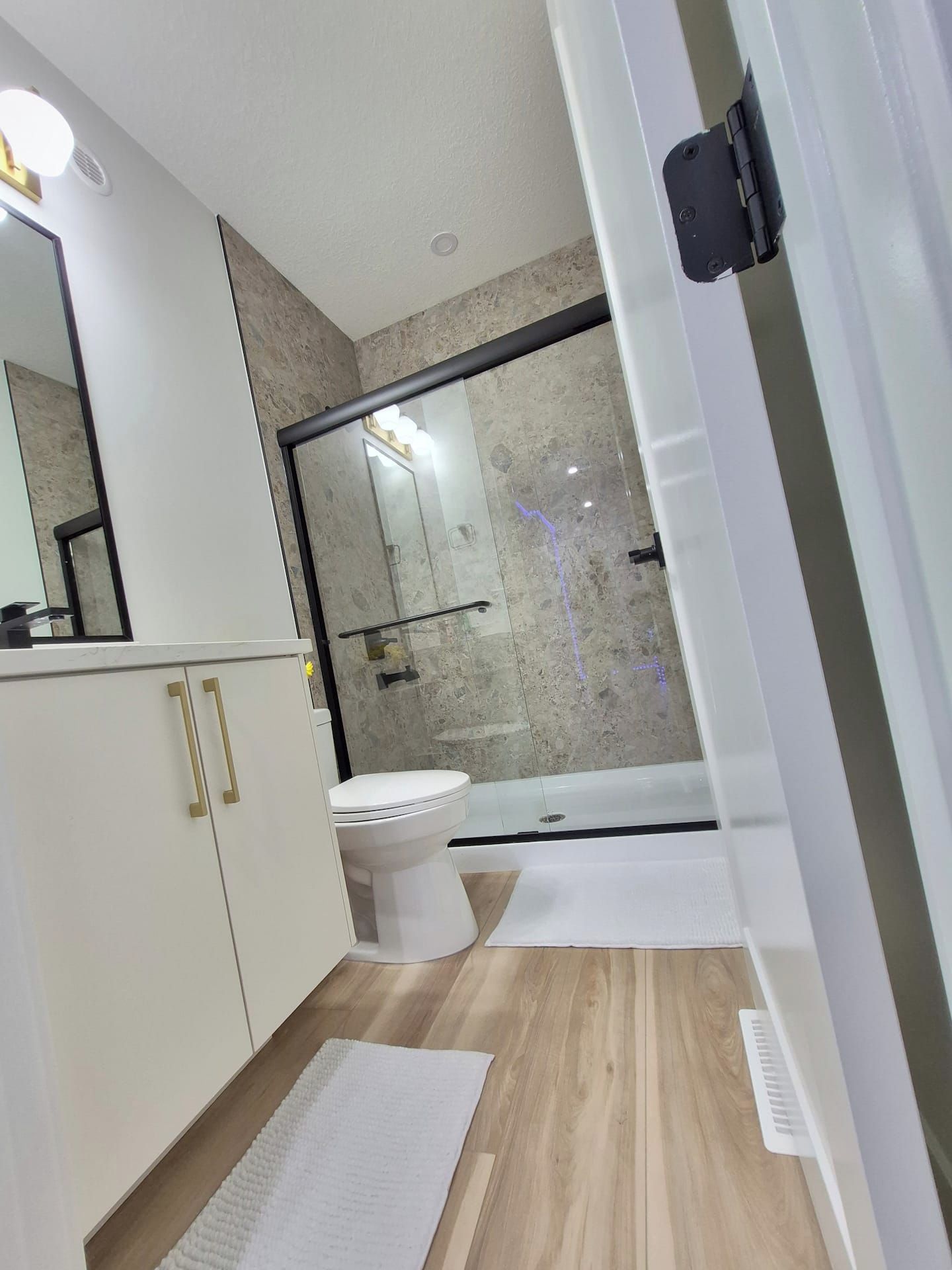 Un baño moderno con inodoro, lavamanos y zona de ducha.
