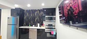 Eine moderne Küche mit Kühlschrank, Mikrowelle, Backofen und Spüle.