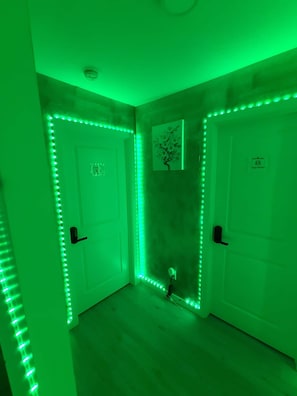 Ein Zimmer mit grüner LED-Beleuchtung entlang der Wände und Türen.