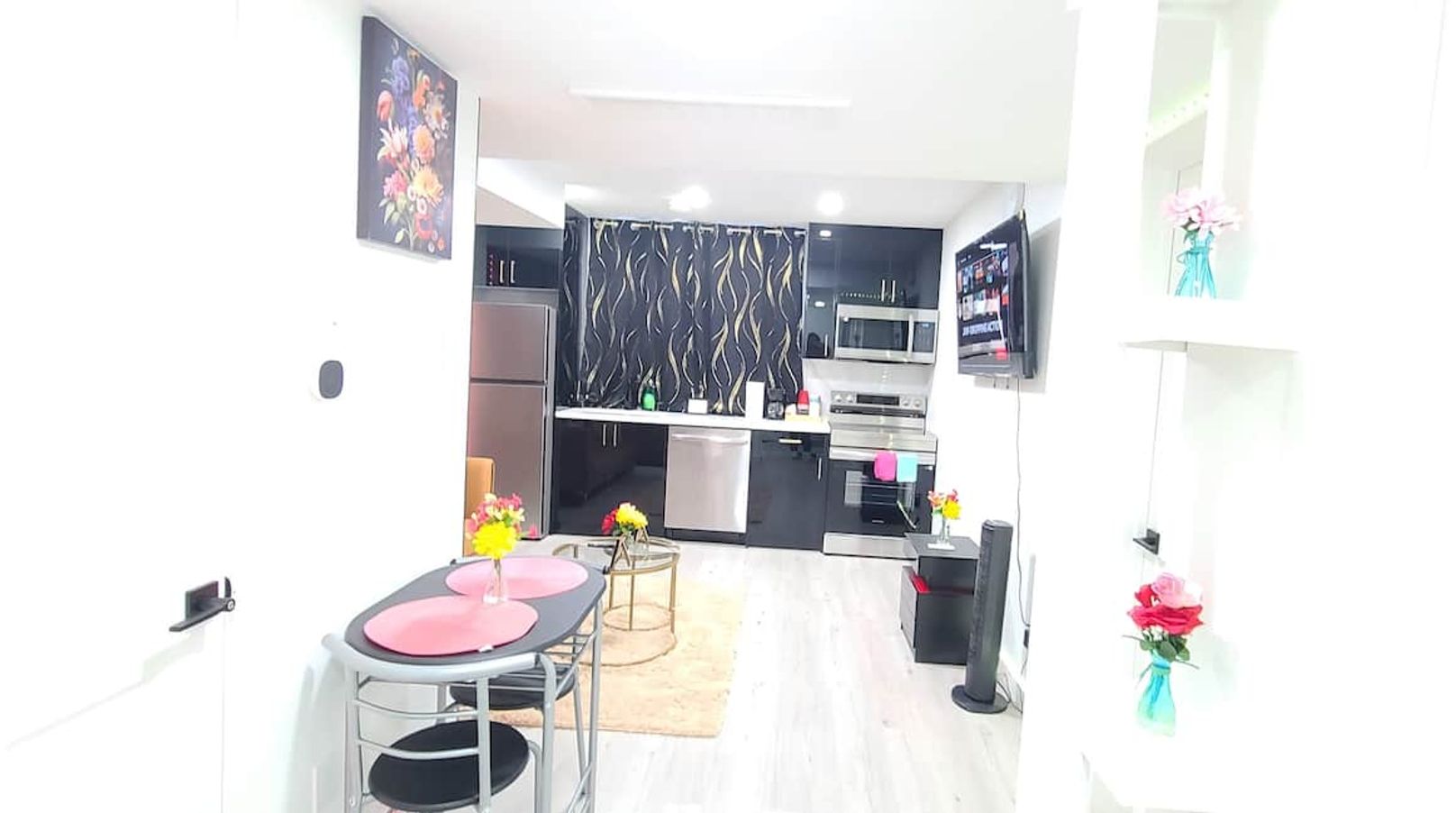 A compact kitchen with modern appliances, a dining area with a table and chairs, and a small seating area with a sofa.