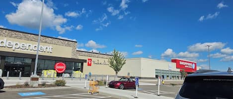 Ein Parkplatz mit Behindertenparkplätzen, einer Apotheke und einem Supermarkt.
