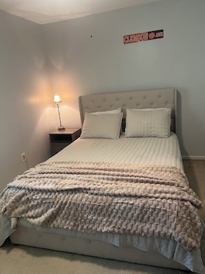 A bedroom with a bed, a nightstand, a lamp, and a wall sign. - Clemson Game-Day Retreat - 4BR, Sleeps 8, 5 Min to Death Valley (Clemson)