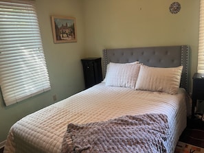A bedroom with a bed, a headboard, a nightstand, a dresser, a painting on the wall, and a window with blinds. - Clemson Game-Day Retreat - 4BR, Sleeps 8, 5 Min to Death Valley (Clemson)