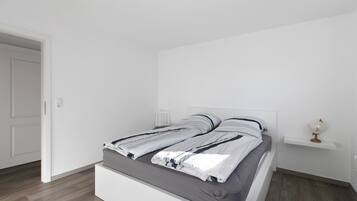 Ein modernes Schlafzimmer mit einem Bett, einem Nachttisch und einem Globus auf einem Regal.