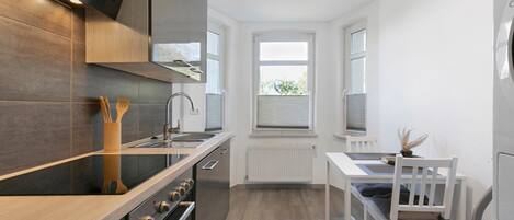 A modern kitchen with a built-in oven, a stovetop, and a window.