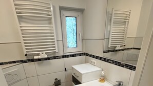 Casa de banho compacta com sanita, lavatório e espelho.