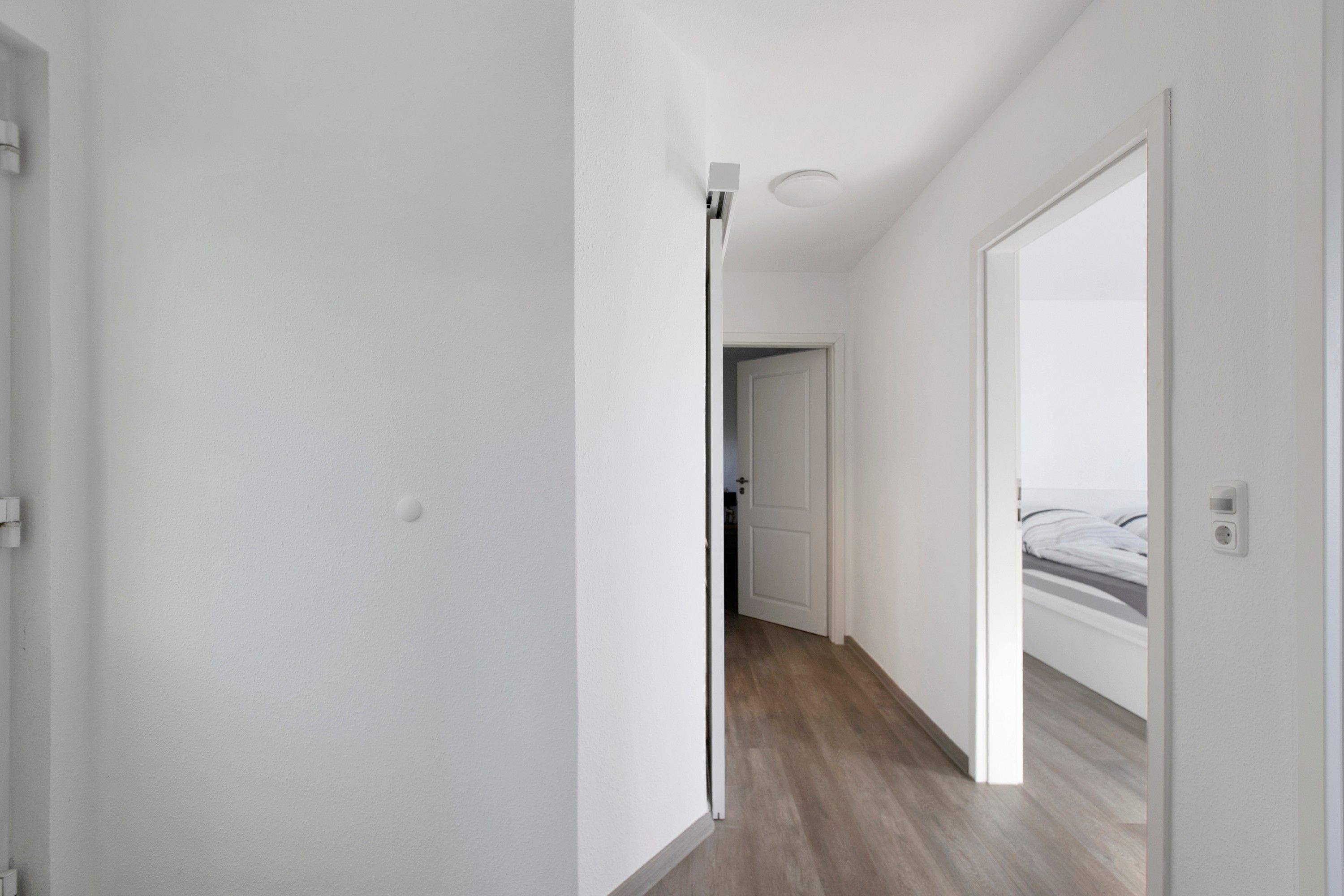 Ein Flur mit einer Tür zu einem Schlafzimmer.
