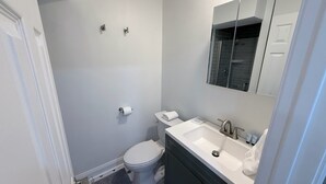 A bathroom with a toilet, sink, and mirror. - 1BR in Logan Circle - DC Metro - We Host (Washington)
