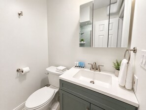 A modern bathroom with a toilet, sink, and mirror. - 1BR in Logan Circle - DC Metro - We Host (Washington)