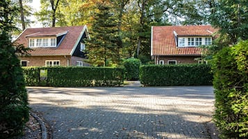 Een woonwijk met twee huizen, een verharde oprit en een haag.