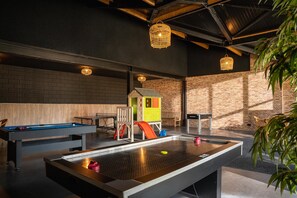 A pool table, a ping pong table, and a children's play area with a slide.
