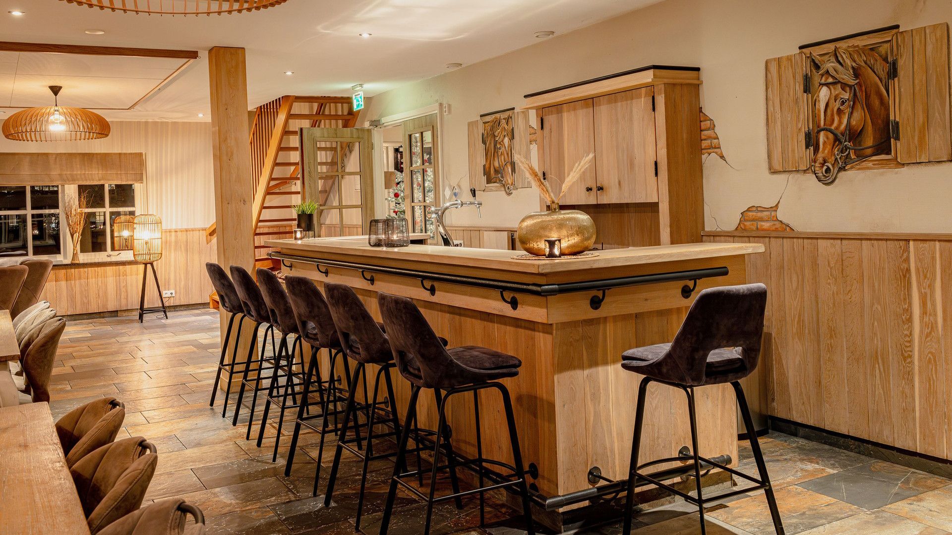 Una zona de bar con taburetes de madera y una barra central.