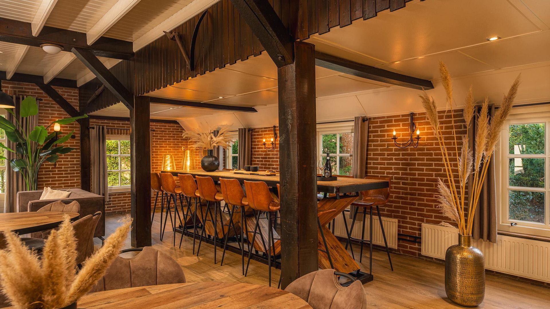 A restaurant with a rustic interior, featuring exposed brick walls, wooden beams, and a bar area with stools.