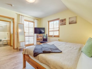 A bedroom with a bed, a television, a window, and a door leading to a bathroom. - 4.4/t3 Holiday Home Park \"freesenbruch\" (Zingst)