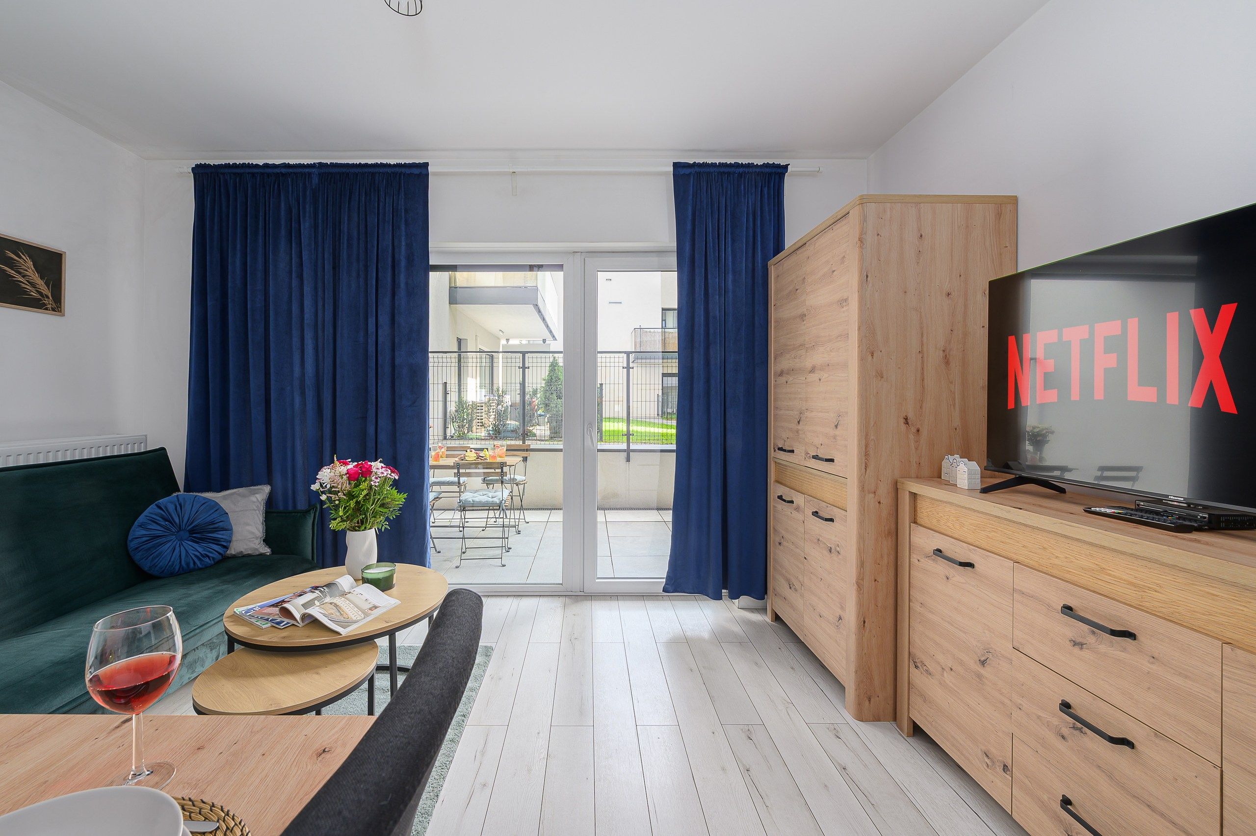 Een moderne woonkamer met een bank, salontafel en een televisie waarop het Netflix-logo te zien is.