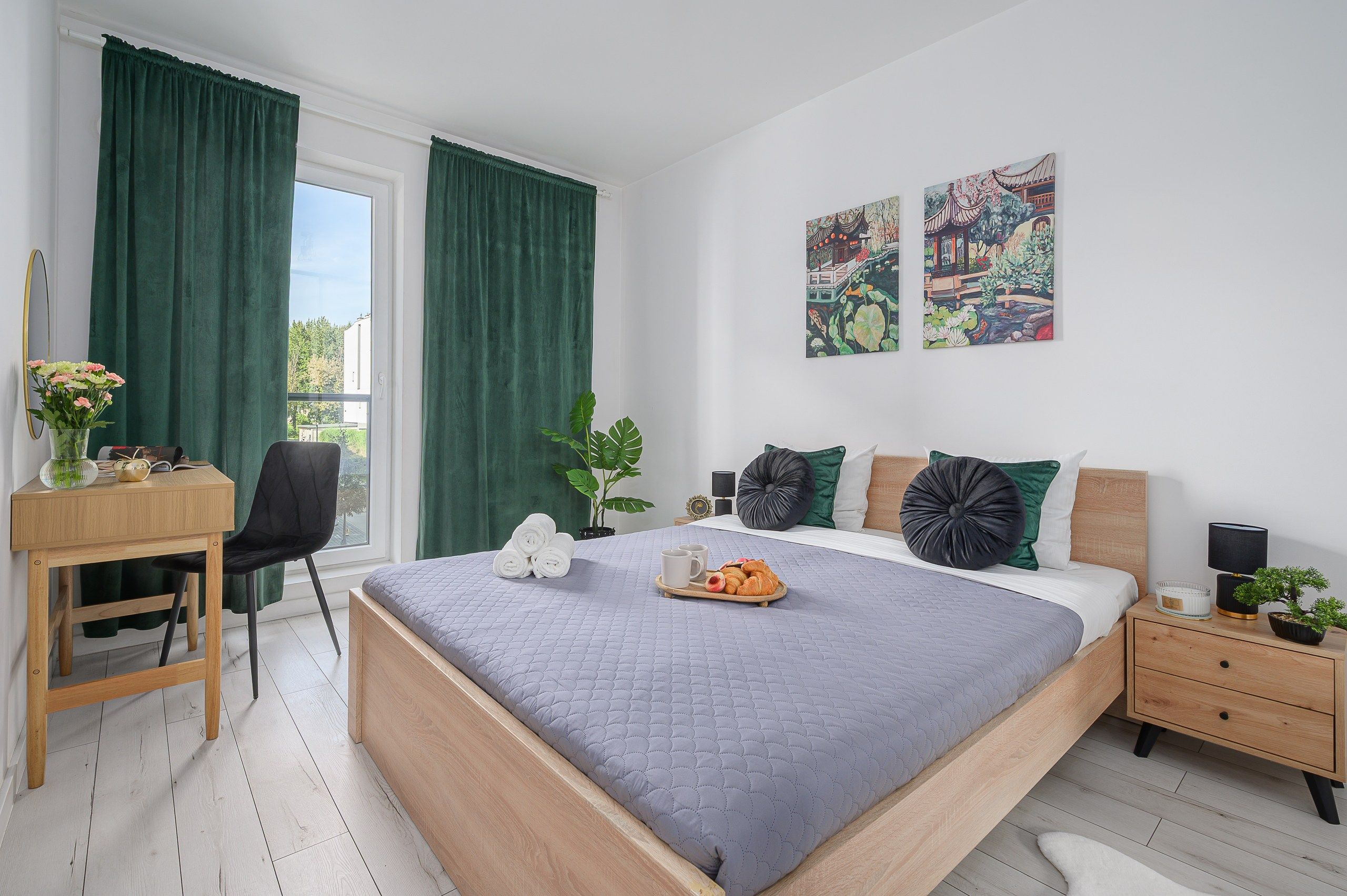 Un dormitorio con cama, mesitas de noche, escritorio y silla.