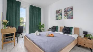 A bedroom with a bed, bedside tables, a desk, and a chair.