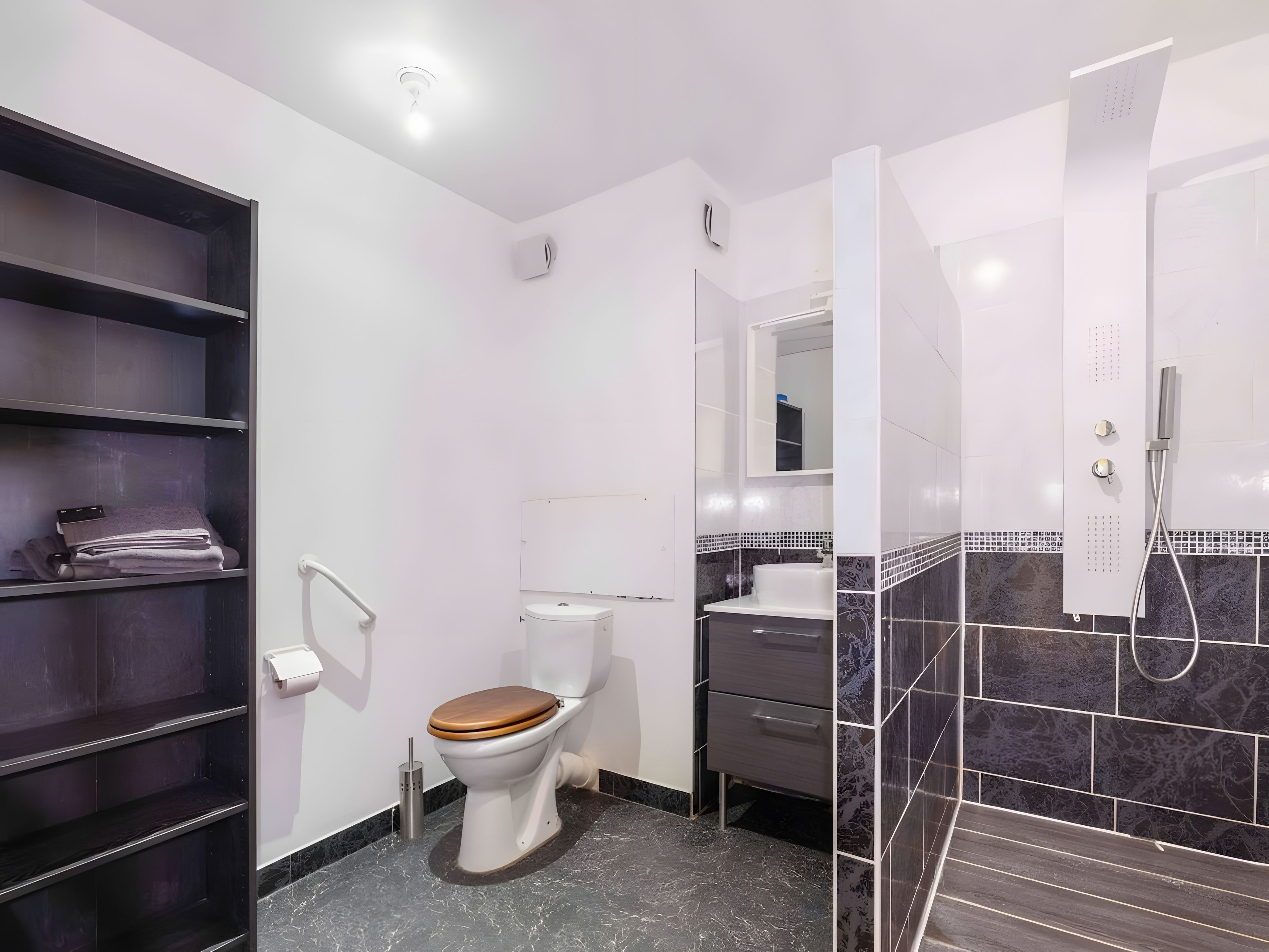 Un baño moderno con inodoro, ducha y tocador.