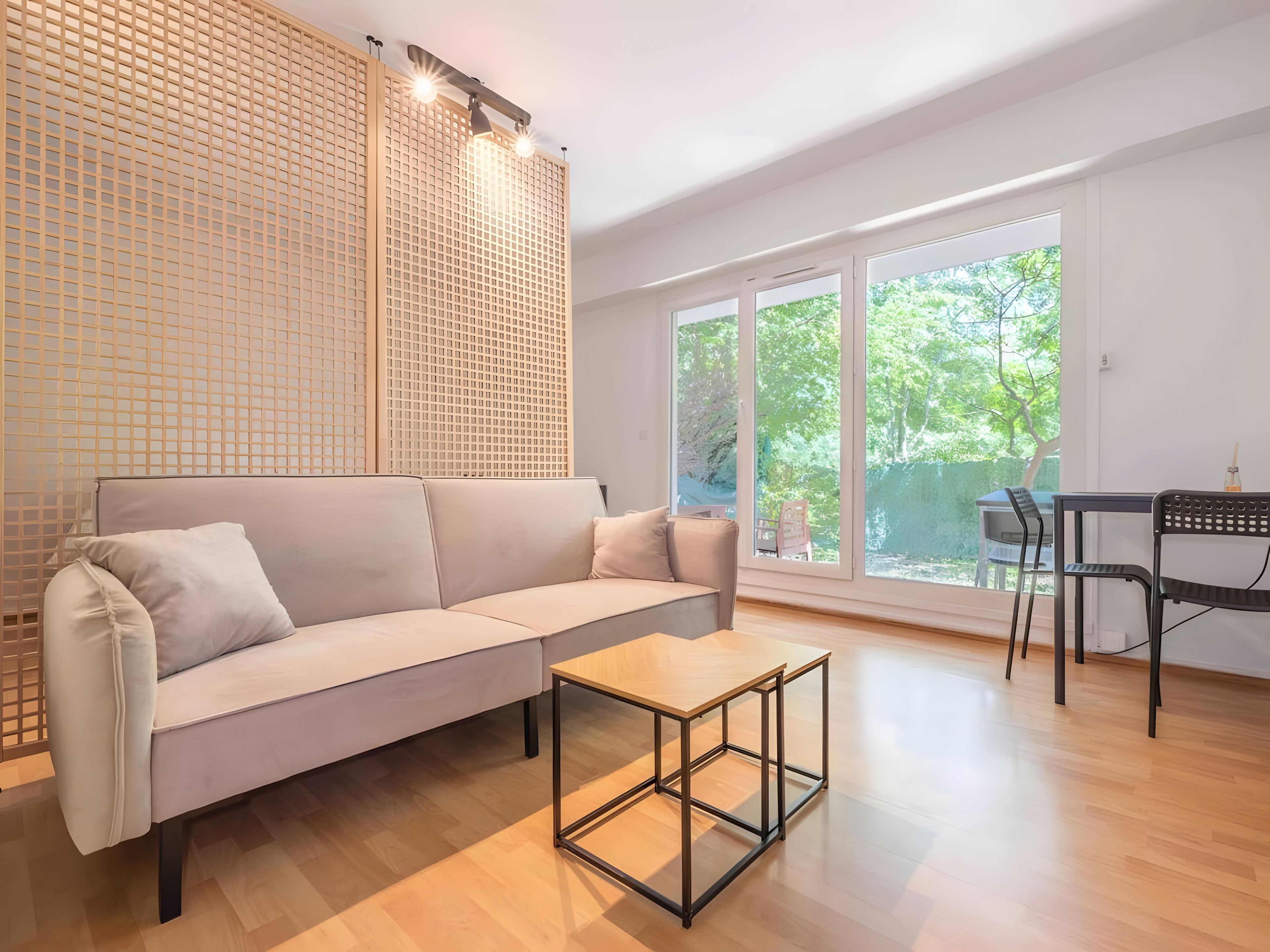 Een moderne woonkamer met een bank, een salontafel en een eethoek met stoelen.