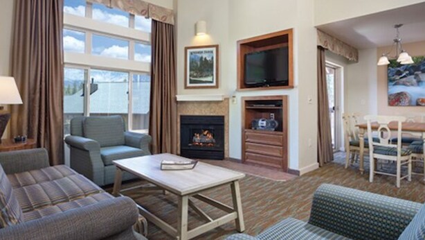 A living room with a fireplace, television, and seating area. - WM BLOCK Reno 1br (Reno)