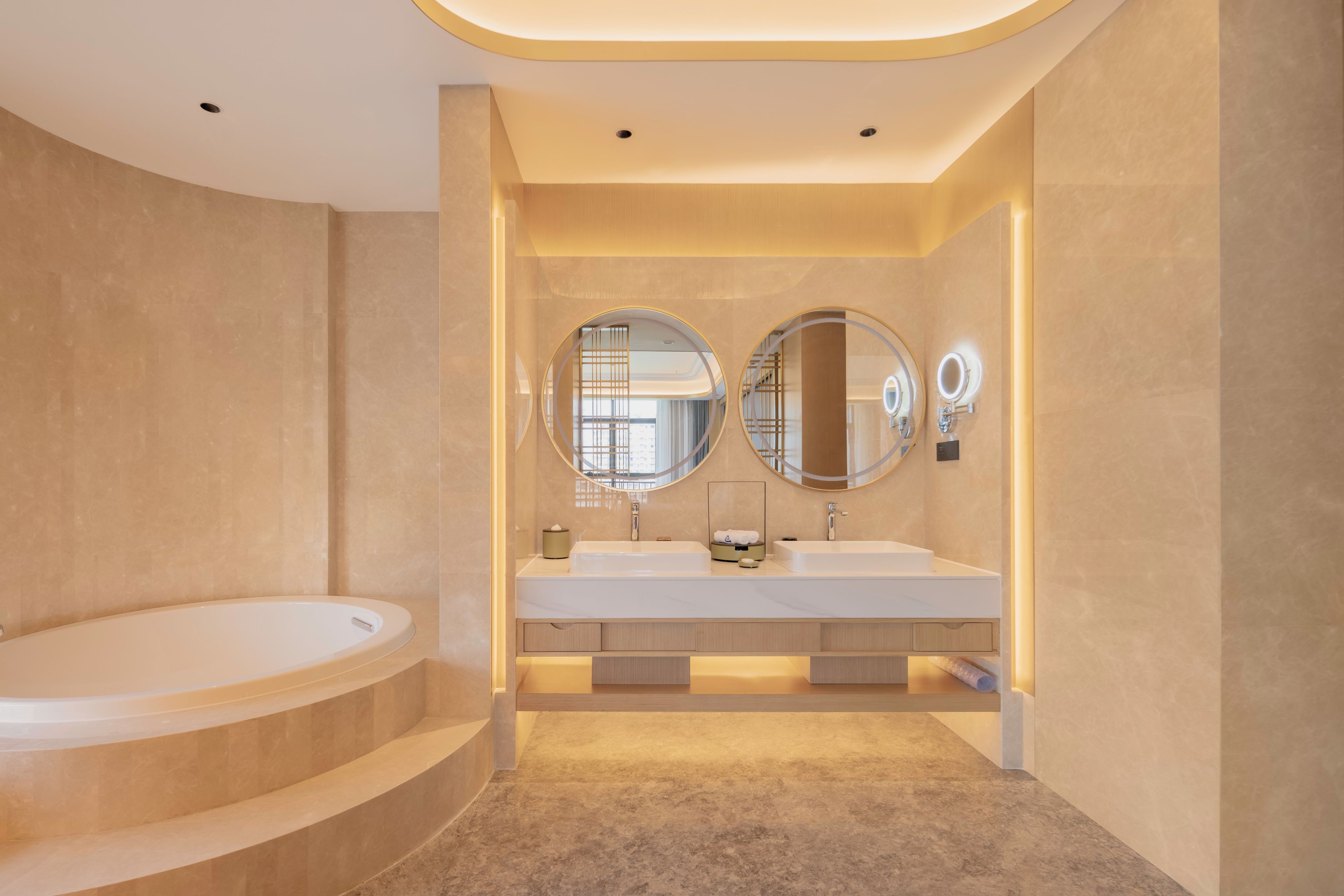 A modern bathroom with a freestanding bathtub, two sinks, and large mirrors.