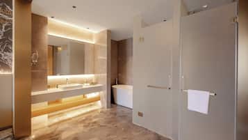 Un baño moderno con un espejo grande, dos lavamanos, una bañera y una ducha a pie.