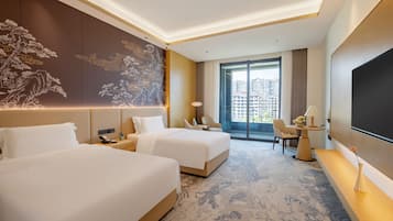 A hotel room with two beds, a large wall mural, a balcony with a view of buildings, and a flat-screen TV.