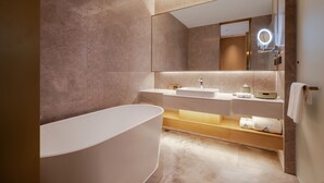 A modern bathroom with a freestanding bathtub, a large mirror with a round light, and a vanity with a sink and towel rack. - Grand Skylight Hotel Jingdezhen (Jingdezhen)
