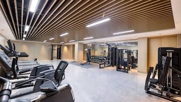 A gym with treadmills, weight machines, and free weights.