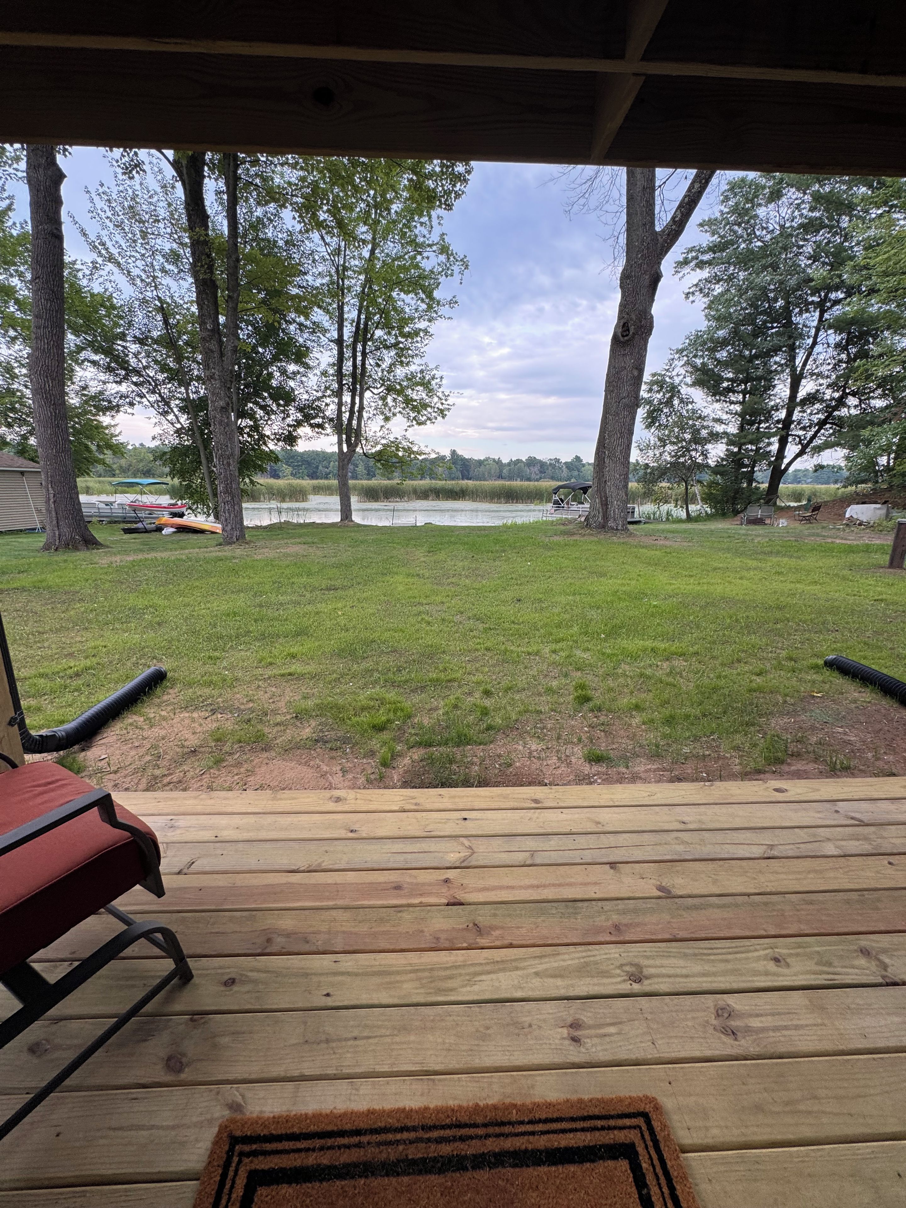 Una terraza de madera con vista a un lago y árboles.