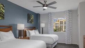 A hotel room with two beds, a ceiling fan, a window with patterned curtains, and artwork on the walls. - WM BLOCK Plaza Resort and Spa 1br (Palm Springs)