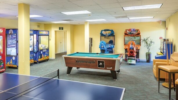 A recreational area with a pool table, arcade games, and seating. - WM BLOCK Plaza Resort and Spa 1br (Palm Springs)