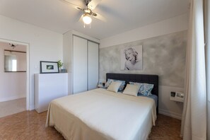A bedroom with a bed, a ceiling fan, a wall-mounted picture, and a door. - Spacious 9-bedroom house with pool and cinema (Kaštel Novi)