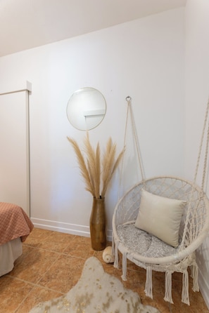 A room with a hanging chair, a mirror, and a vase with pampas grass. - Spacious 9-bedroom house with pool and cinema (Kaštel Novi)