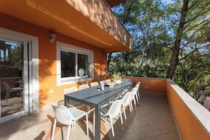 A patio with a table and chairs, a potted plant, and a window. - Spacious 9-bedroom house with pool and cinema (Kaštel Novi)