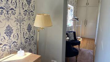 A room with a wooden desk, a lamp, a chair, and a wardrobe.