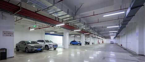 A multi-level parking garage with several cars parked, clear signage, and a clean, well-lit environment.