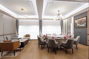 A modern dining area with a round table set for six, surrounded by six chairs.