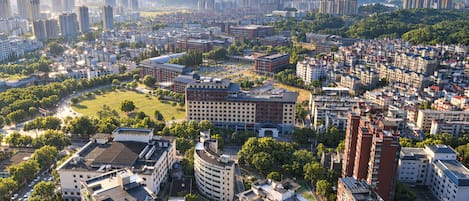 A cityscape with high-rise buildings, a central green park, and a mountainous backdrop.