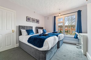 A bedroom with two beds, a window with curtains, and a desk. - House Sleeps 7 With Enclosed Garden (Coventry)