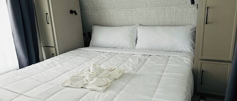 Une chambre d’hôtel avec un lit, une armoire et une tête de lit.