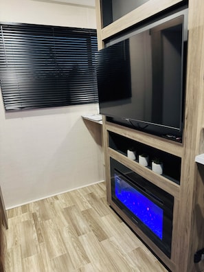 A modern entertainment unit with a flat-screen TV and a built-in sound system.