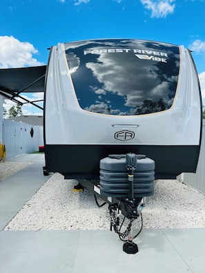 A recreational vehicle with a large rear window and a logo on the back.