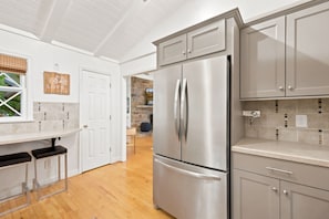 A modern kitchen with stainless steel appliances, white cabinetry, and a wooden floor. - 4-bedroom home on the Misty Mountain in gorgeous Blowing Rock! (Blowing Rock)