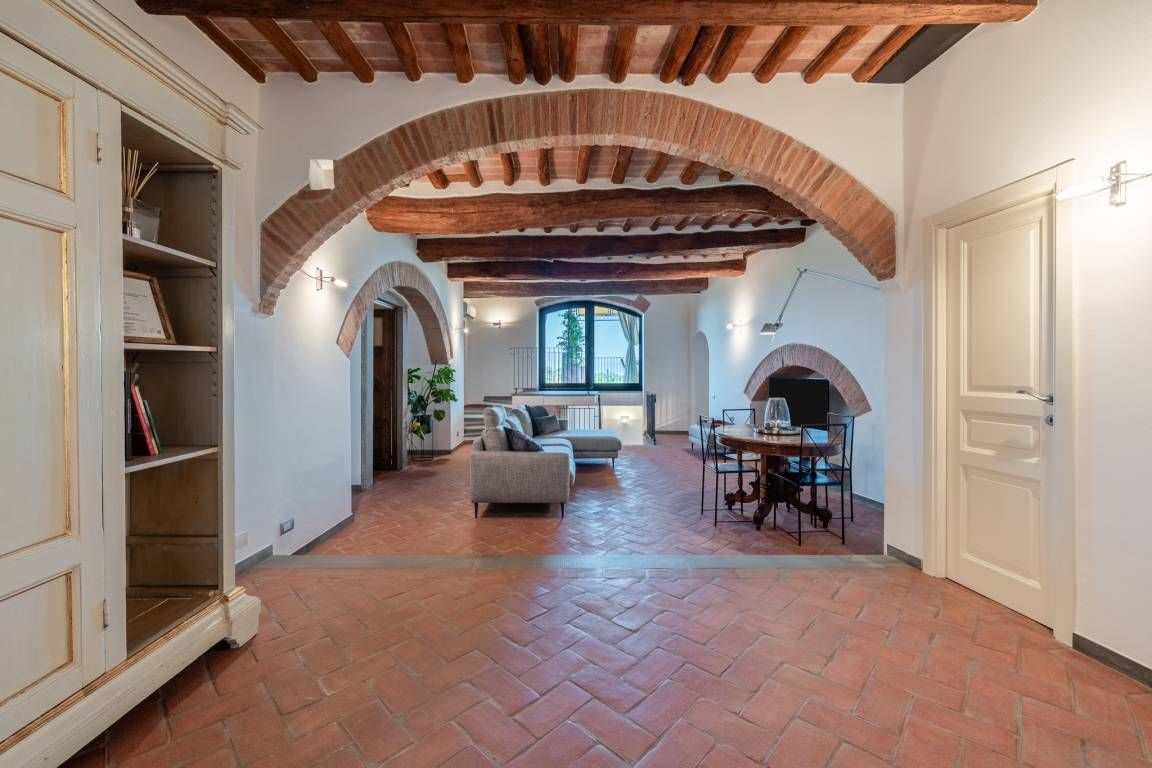 Amplia sala de estar con chimenea, un sofá y una mesa de comedor.